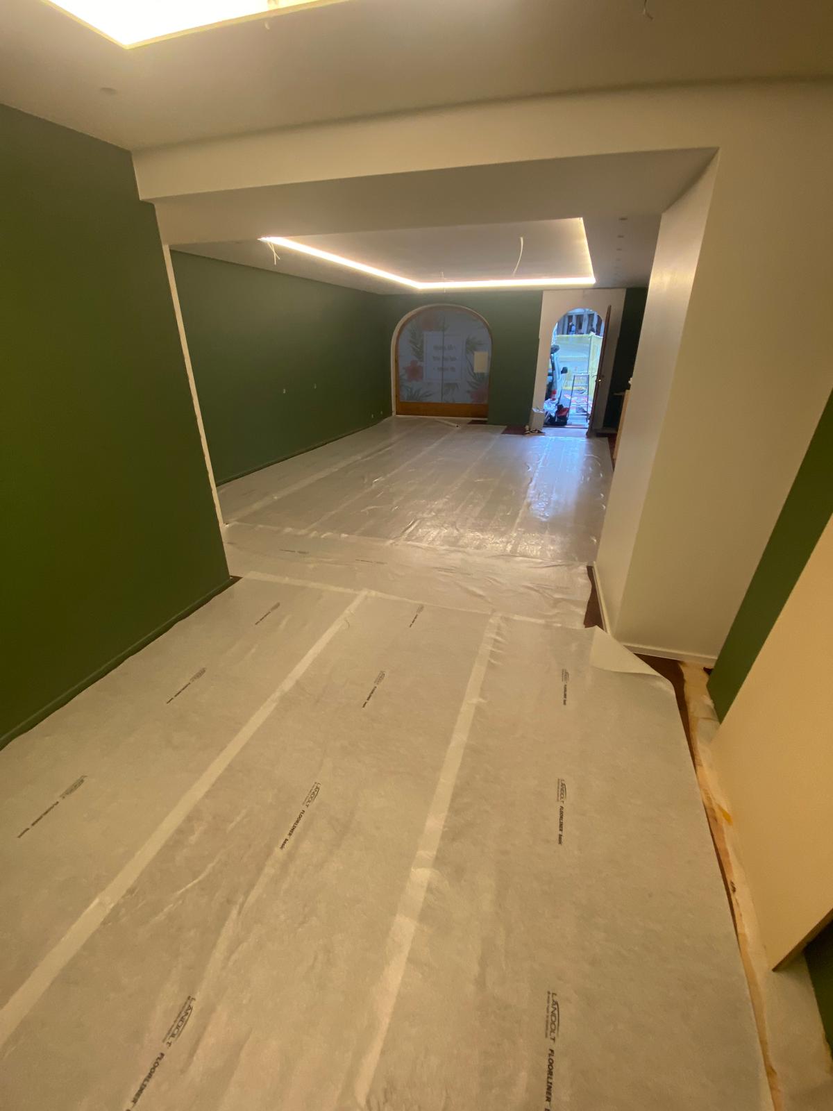 Couloir et salon peints en vert sauge avec corniche lumineuse LED et arches