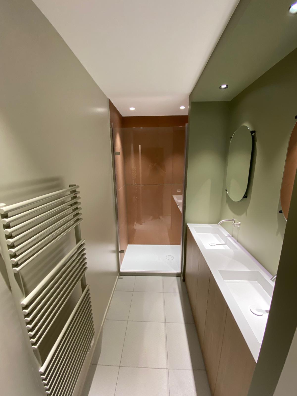 Salle de bain rénovée avec peinture vert d'eau, douche italienne et carrelage cuivre